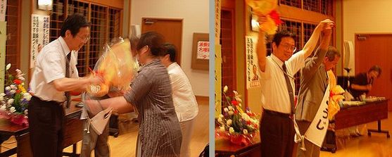 花束をかかげ、激励に応える松本、平賀氏